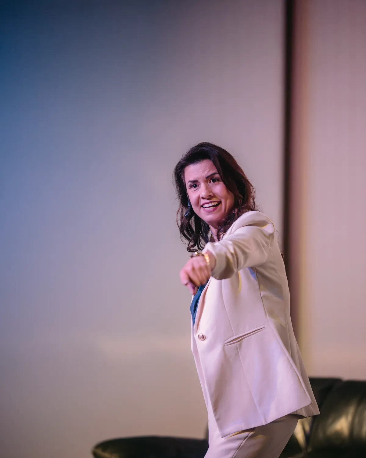 Renata Bertagnoli palestrando no palco e apontando para o público