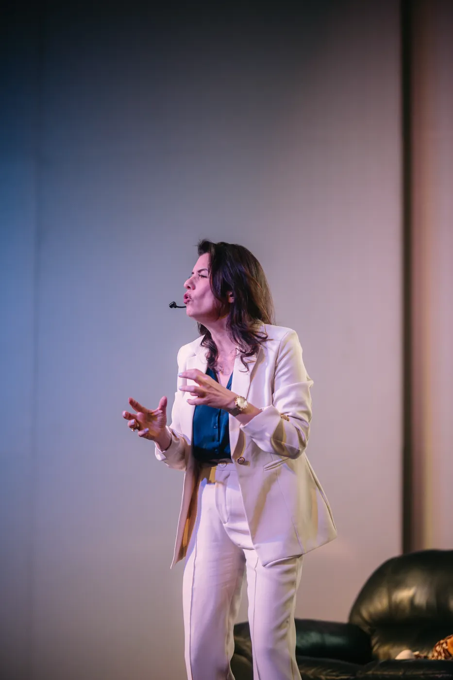 Renata Bertagnoli gesticulando enquanto explica um conceito no palco